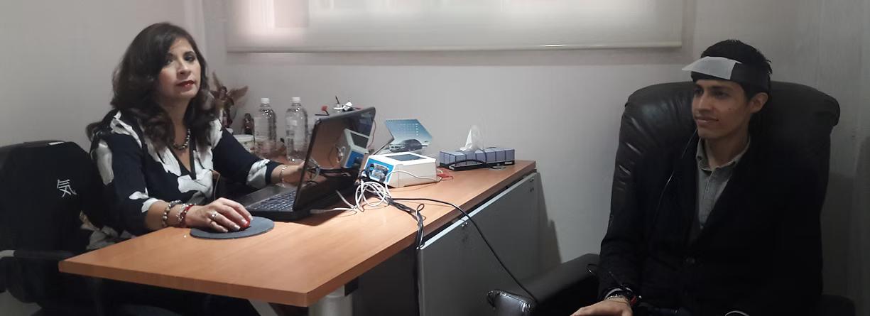 Dos personas en un consultorio, una con banda de sensores en la cabeza